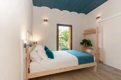 a bedroom with a bed and a window at ecoGrusApartments in Masnou