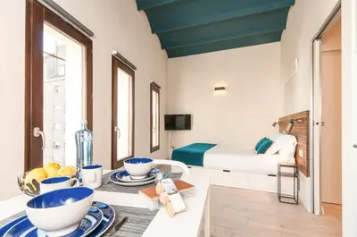 a room with a bed and a table with bowls on it at ecoGrusApartments in Masnou