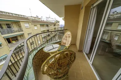 a balcony with two chairs and a table on a building at HomeHolidaysRentals Belisa - Costa Barcelona in Pineda de Mar