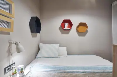 a bedroom with a bed with three boxes on the wall at Spacious 3BRapartment in PobleSec with balcony in Barcelona