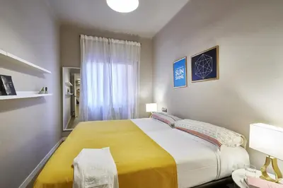 a bedroom with a large bed with a yellow blanket at Spacious 3BRapartment in PobleSec with balcony in Barcelona