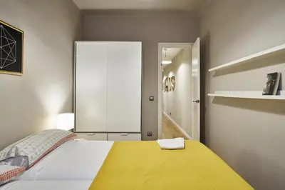 a bedroom with a large bed with a yellow blanket at Spacious 3BRapartment in PobleSec with balcony in Barcelona