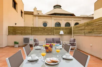 a table with food and drinks on a patio at Matarolux28 in Mataró