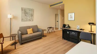 a living room with a couch and a table at Sercotel Barcelona El Prat in El Prat de Llobregat