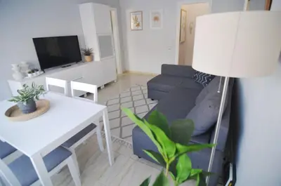 a living room with a blue couch and a table at HomeHolidaysRentals Blue - Costa Barcelona in Pineda de Mar