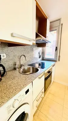 a kitchen with a sink and a washing machine at Dúplex ático familiar by Prestigi in Terrassa