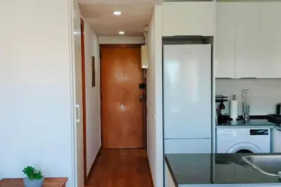 a kitchen with a white refrigerator in a room at Apartamento con vista al mar in Vilanova i la Geltrú