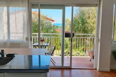 a kitchen with a sliding glass door leading to a balcony at Apartamento con vista al mar in Vilanova i la Geltrú