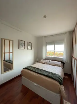 a bedroom with a large bed with a window at Apartamento en el centro urbano in Vilanova i la Geltrú