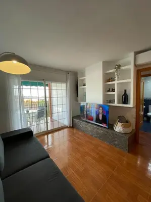 a living room with a couch and a flat screen tv at Apartamento en el centro urbano in Vilanova i la Geltrú