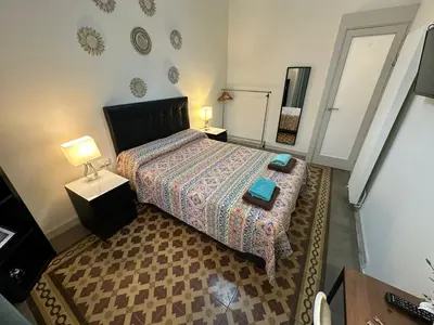 a bedroom with a bed and two lamps and a table at Habitaciones Roger in Barcelona