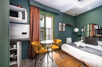 a bedroom with a bed and a table and chairs at AinB Born-Dames Apartments in Barcelona