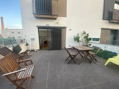a patio with chairs and a table and a building at Long Stays Terrassa Near Center in Terrassa
