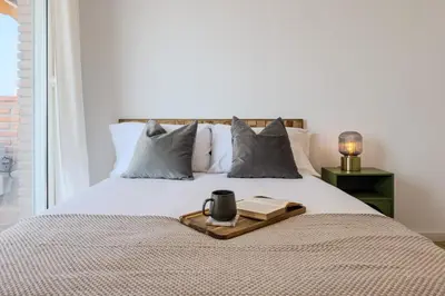 a bed with a tray with a book and a candle on it at Sagrada in Barcelona