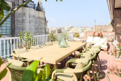 a wooden table and chairs on a balcony at Sagrada in Barcelona