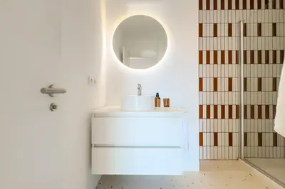 a white bathroom with a sink and a mirror at Sagrada in Barcelona