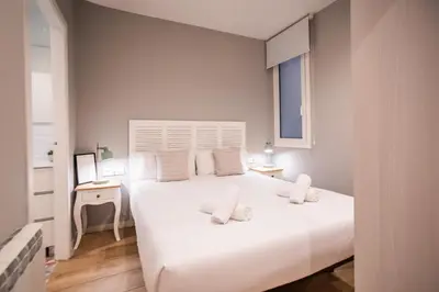 a white bedroom with a large white bed and a desk at B3MAL1081- New 2BR flat with private terrace in Barcelona