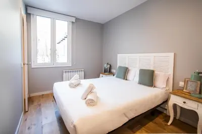 a bedroom with a large white bed with towels on it at B3MAL1081- New 2BR flat with private terrace in Barcelona