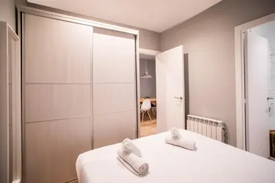a bedroom with a white bed and a mirror at B3MAL1081- New 2BR flat with private terrace in Barcelona