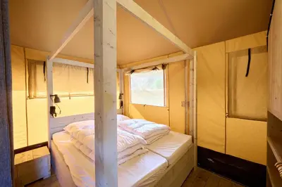 a bed in a room with a pole at Glamping Costa Dorada in Vilanova i la Geltrú