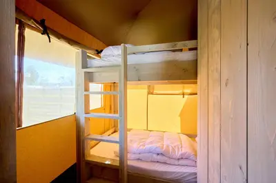 a bunk bed in a room with a ladder at Glamping Costa Dorada in Vilanova i la Geltrú