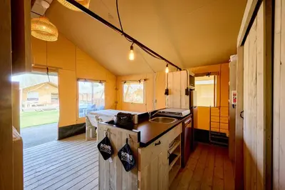 a patio with a wooden bench and a table at Glamping Costa Dorada in Vilanova i la Geltrú