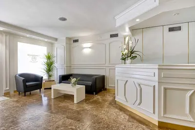 a lobby with two chairs and a table and a mirror at Bonanova Suite in Barcelona