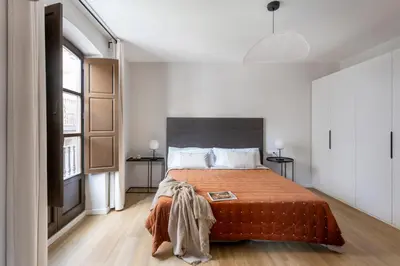 a bedroom with a large bed with a orange blanket at Serra house premium apartments in Barcelona