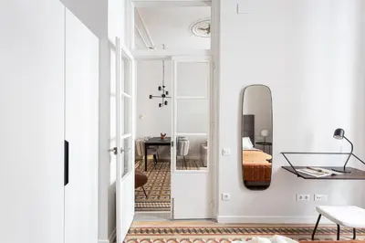 a hallway with a mirror and a room with a bed at Serra house premium apartments in Barcelona