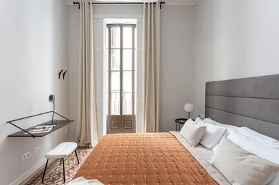 a bedroom with a large bed and a desk at Serra house premium apartments in Barcelona