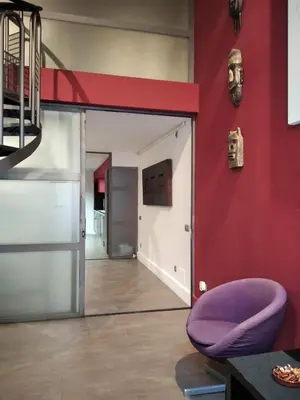 a room with a red wall and a purple chair at ApartEasy - MONUMENT, large, cosy apartment in Barcelona