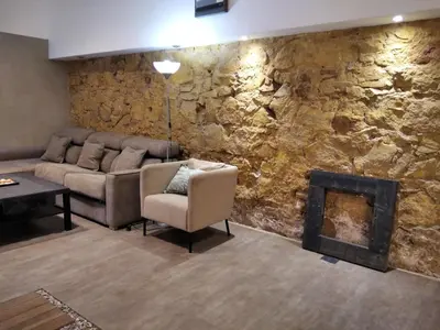 a living room with a couch and a stone wall at ApartEasy - MONUMENT, large, cosy apartment in Barcelona