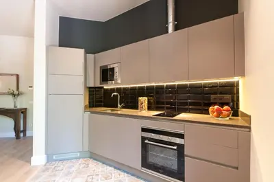 a kitchen with white cabinets and a sink at Weflating Suites Sant Antoni Market in Barcelona