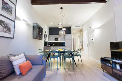 a living room with a couch and a table and chairs at Weflating Suites Sant Antoni Market in Barcelona