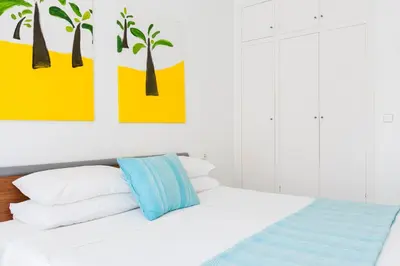 a bedroom with a bed with colorful paintings on the wall at Viva Sitges - Mayo Terrace in Sitges