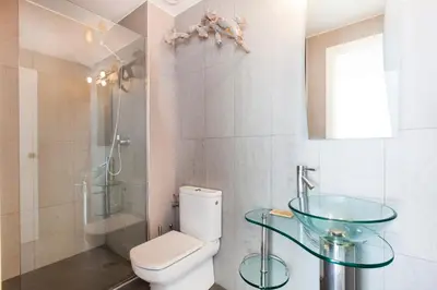 a bathroom with a toilet and a glass sink at Viva Sitges - Mayo Terrace in Sitges