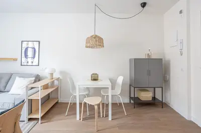 a living room with a table and a bed at Modern 1 bedroom apartments near Parallel in Barcelona