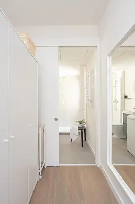 a hallway with white walls and a door leading to a kitchen at Modern 1 bedroom apartments near Parallel in Barcelona