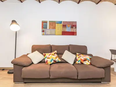 a brown couch with pillows in a living room at Apartment Eixample Dret Aragó Roger de Lluria by Interhome in Barcelona