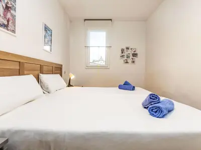 a bedroom with a large white bed with blue towels on it at Apartment Eixample Dret Aragó Roger de Lluria by Interhome in Barcelona