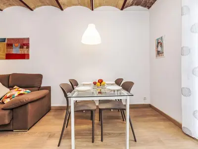 a dining room table with chairs and a couch at Apartment Eixample Dret Aragó Roger de Lluria by Interhome in Barcelona