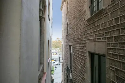 an alley between two tall buildings with a door at Alcam Dali in Barcelona