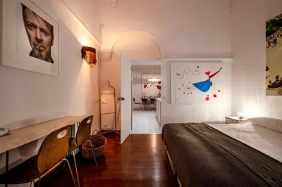 a bedroom with a bed and chairs and a hallway at Canela Homes BARCELONA PERMANYER in Barcelona