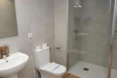 a bathroom with a shower and a toilet and a sink at Homenfun Dalt Badalona in Badalona