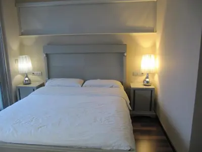 a bedroom with a large white bed with two lamps at Torre Forum in Sant Adria de Besos
