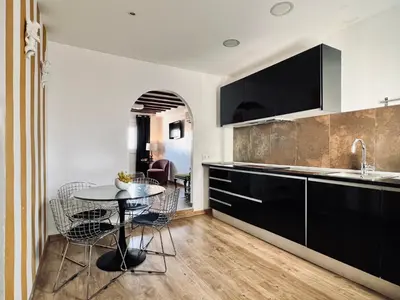 a kitchen with black cabinets and a table with chairs at Diamond Rooftop & private terrace sea views in Barcelona