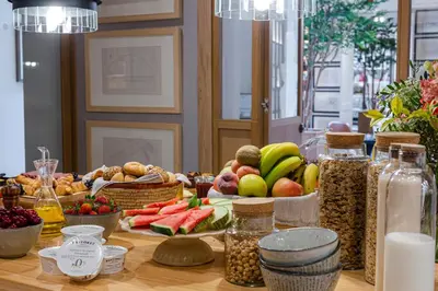 a table topped with bowls of fruit and other foods at Hotel Margot House Barcelona in Barcelona