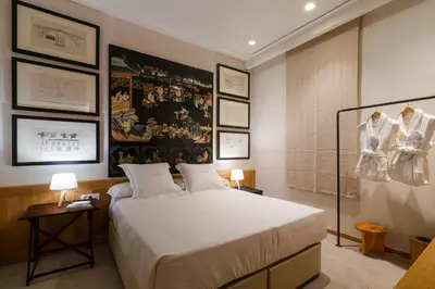 a bedroom with a bed and a wall with pictures at Hotel Margot House Barcelona in Barcelona