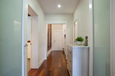 a bathroom with white walls and a wooden floor at Tendency Rambla Catalunya in Barcelona