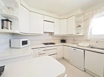 a white kitchen with white cabinets and a sink at BCN | Duplex Penthouse & Pool in Sant Andreu de Llavaneres